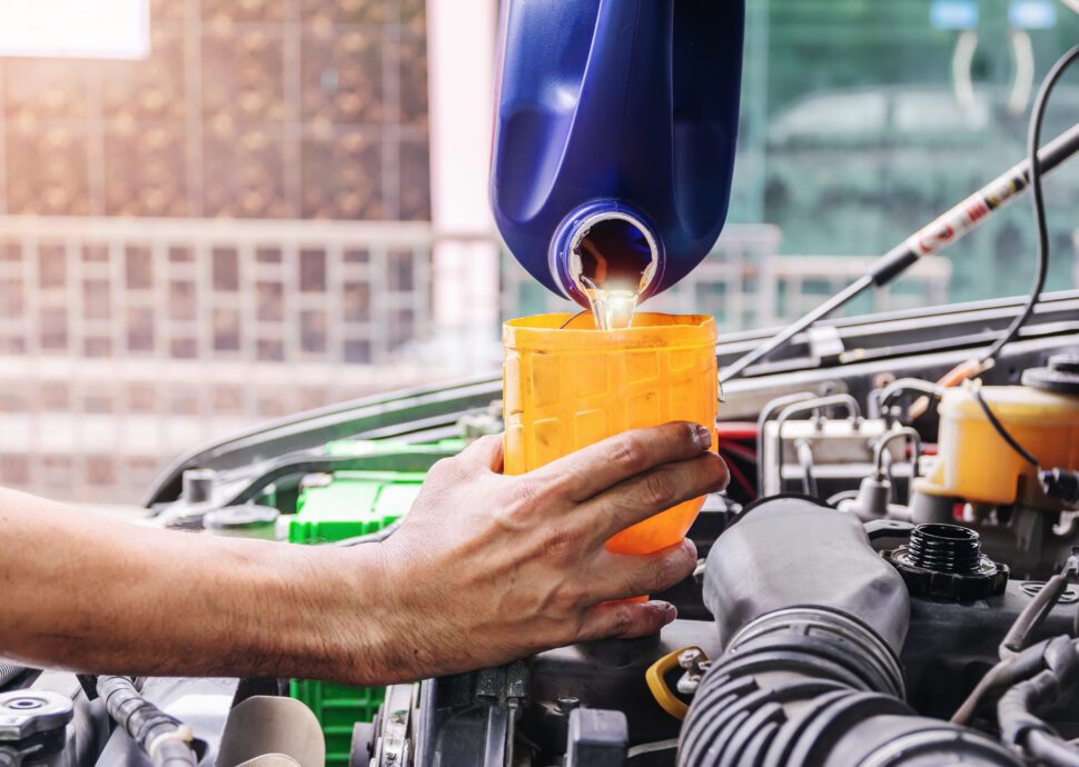 Auto mechanic filling up car engine oil